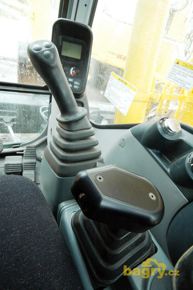 V popředí joystick ovládání radlice