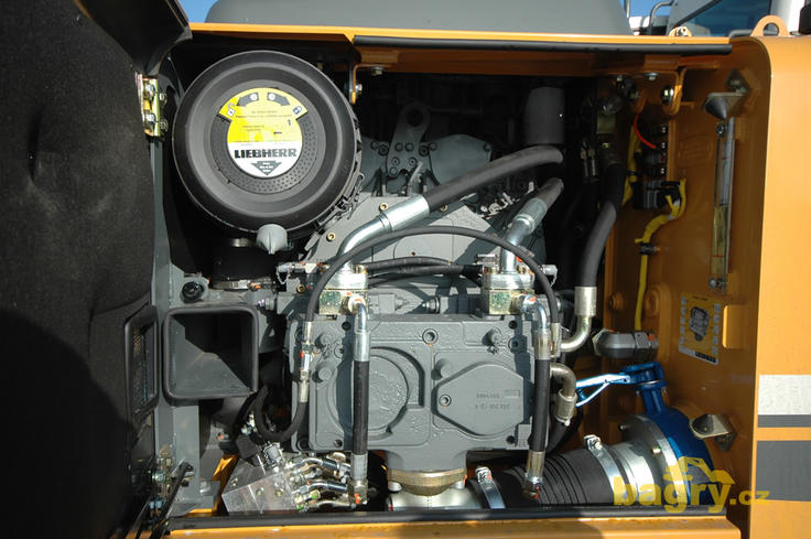 Hydraulická čerpadla jsou ukryta pod pravým zadním krytem kapoty