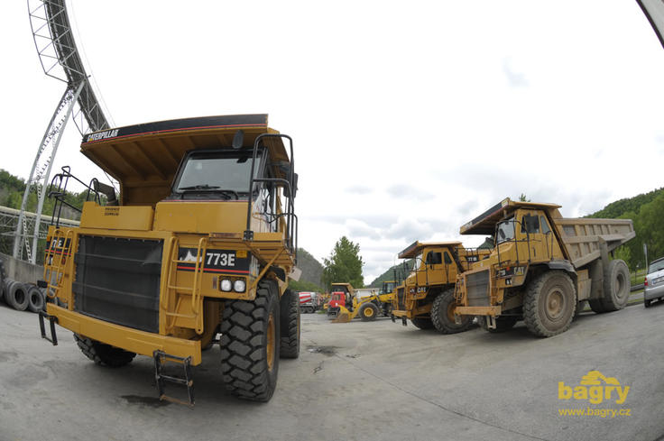 Pevný dempr Caterpillar 773E vedle řady demprů 773B