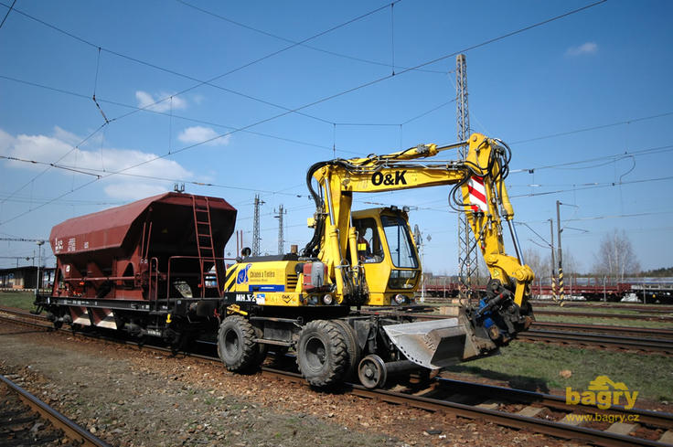 Dvoucestné rypadlo O&K MH S-2 firmy Chládek a Tintěra Havlíčkův Brod táhne vagóny se štěrkem