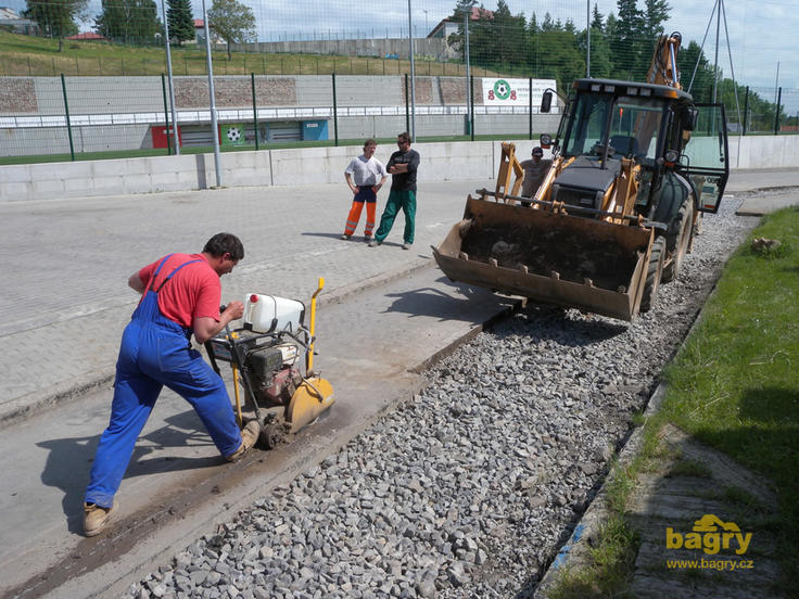 Rypadlonakldač Case 580 Super R, v popředí pracovník s řezačkou spar NTC