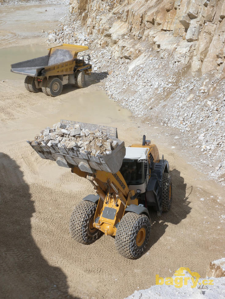 Kolový nakladač Liebherr L 586 2plus2, v pozadí dempr Caterpillar 769C