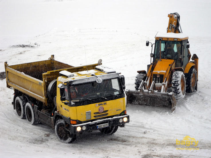 Sklápěč Tatra 815 Terrno1 6x6 míjí rypadlonakladač JCB 4CX