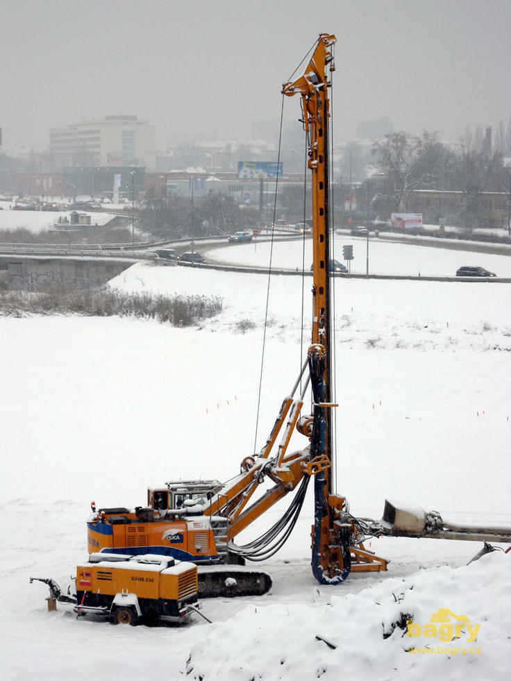 Vrtná souprava Bauer BG 18 H firmy Skanska, v popředí kompresor Atlas Copco XAHS 236