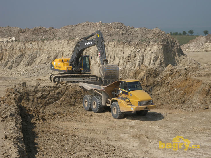 Pásové rypadlo Volvo EC460B LC nakládá kloubový dempr Caterpillar 735