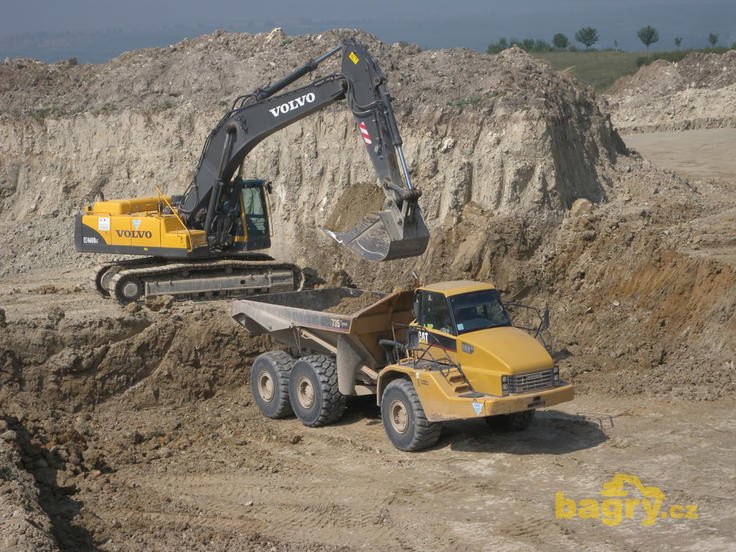 Pásové rypadlo Volvo EC460B LC nakládá kloubový dempr Caterpillar 735