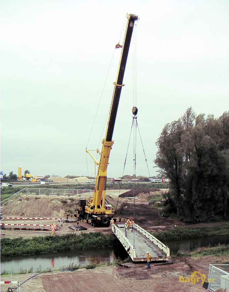 Autojeřáb Liebherr o hmotnosti 400 t pokládá most přes říčku