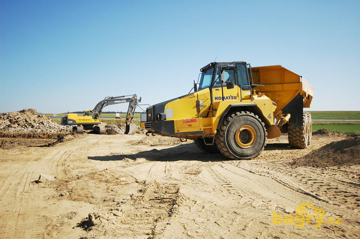 Kloubový dempr Komatsu HM 400 firmy Polanský, v pozadí pásové rypadlo Volvo EC360C L téže firmy