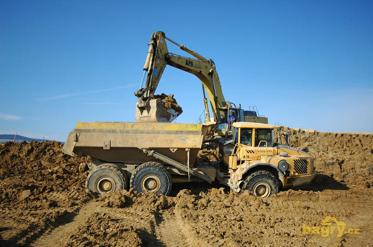 Kloubový dempr Volvo A35D nakládaný pásovým rypadlem Komatsu PC650SE