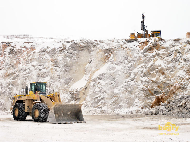 Kolový nakladač Komatsu WA 600 pod lomovými vrtnými soupravami
