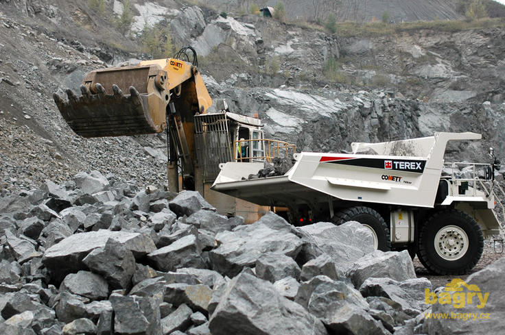 Pásové rypadlo Demag H65 nakládá pevný dempr Terex TR 45