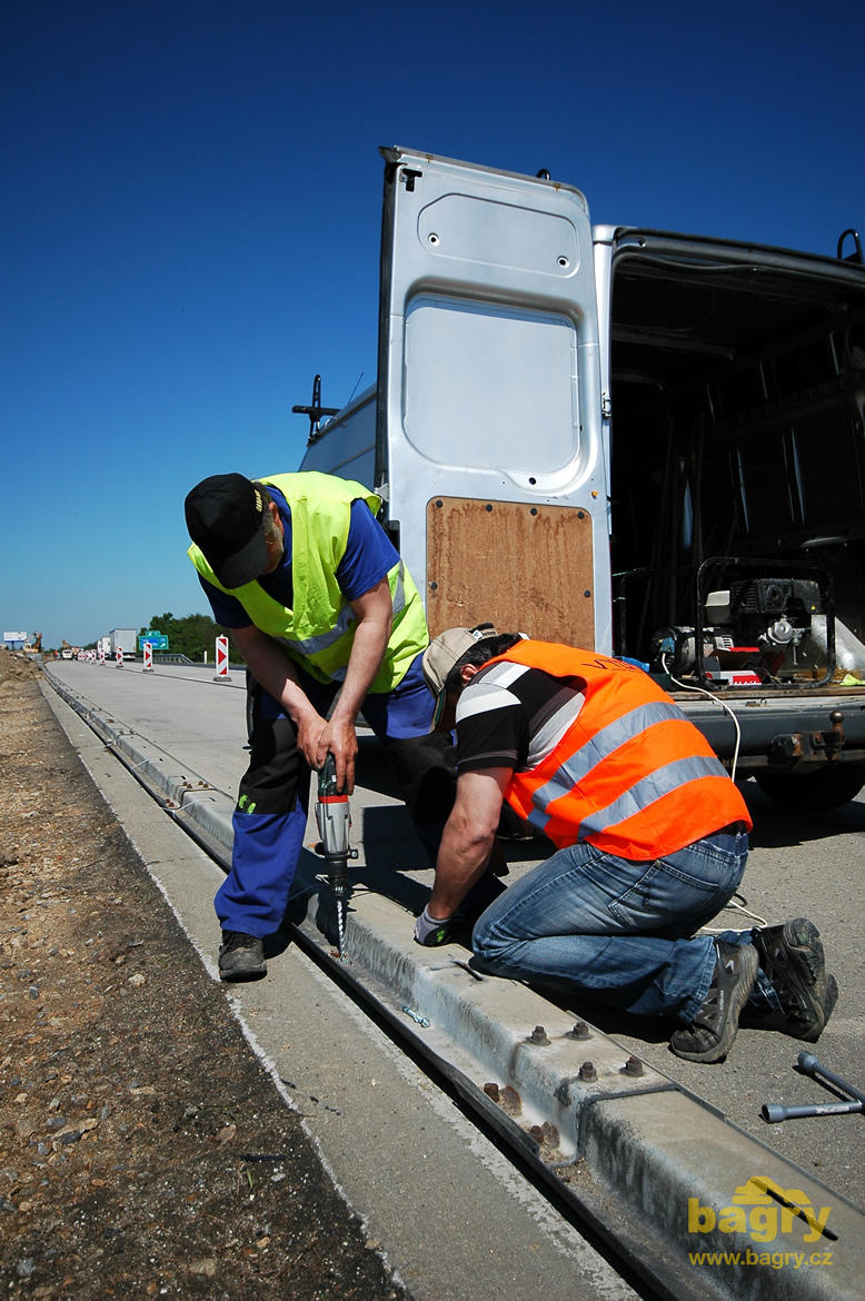 Pracovníci firmy Cesa připevňují chráničku optického kabelu vyrobenou z původních svodidel