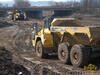 Kloubový dempr Komatsu HM350, v pozadí HM400