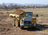 Kloubový dempr Komatsu HM350 zatáčí v bahně
