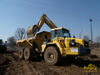 Kloubový dempr Komatsu HM400-1 nakládaný pásovým rypadlem Komatsu PC450 LC-7