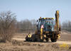 Rypadlonakladač Caterpillar 428C čistí cestu otevřenou klapačkou