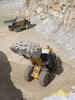 Kolový nakladač Liebherr L 586 2plus2, v pozadí dempr Caterpillar 769C