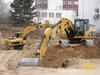 Pásové rypadlo Caterpillar 320D L, v pozadí 323D L s rozrývačem
