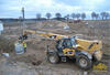 Teleskopický manipulátor Caterpillar TH560B usazuje skruž