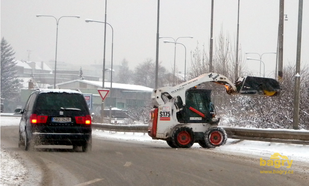 Smykem řízený nakladač Bobcat S175 firmy Marko zemní práce vysypává sníh ze zametače