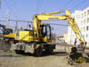 Kolové rypadlo Komatsu PW130 v pozadí Volvo EW160C