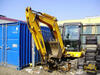 Midirypadlo JCB 8045 ukryté v koutě stavby