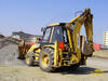 Rypadlo-nakladač Caterpillar 438B firmy OHL ŽS obhrnuje hromadu štěrku