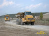Kloubový dempr Caterpillar 735, za ním Volvo A35E