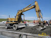 Kolové rypadlo Caterpillar 206B FT firmy Skanska DS rozhrnuje beton před finišerem
