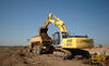 Pásové rypadlo New Holland Kobelco E215 nakládá kloubový dempr Volvo A30D