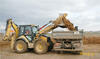 Traktorbagr Caterpillar 434E nakládá materiál