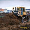 Pásový dozer Caterpillar D6H XL firmy Hochtief na pozadí hotelu International a vrtné soupravy
