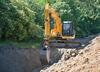 34. Pásové rýpadlo JCB JS 210 při přeložce sítí tech. vybavenosti