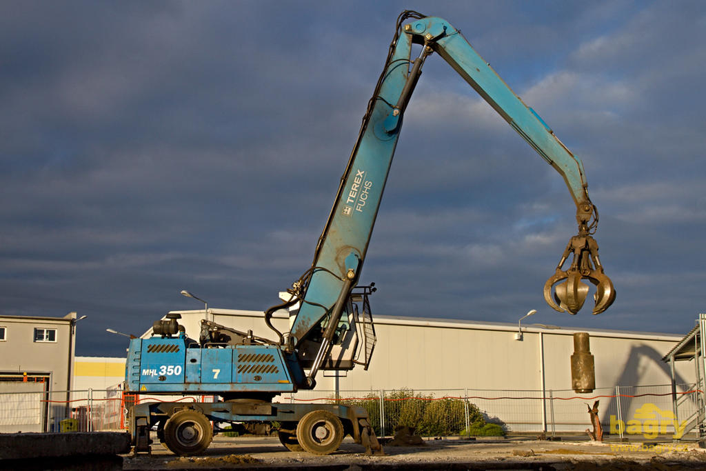 Překládkové rypadlo Terex Fuchs MHL 350 rozbíjí betonovou plochu pro stavbu nové dílny údržby