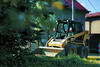 Smykem řízený nakladač Caterpillar 226 na ulici K Pískovně