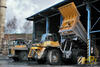 Pevný dempr Komatsu HD605-7, v pozadí Unex Haulpak 210 M