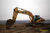 Pásové rypadlo Caterpillar 325D v pozadí s lomem ČSA