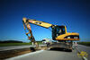 Kolové rypadlo Caterpillar M316C s kladivem vybourává beton z výkopu