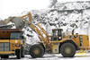 Kolový nakladač Caterpillar 988H nakládá pevný dempr Caterpillar 771D