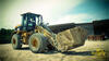 Kolový nakladač Caterpillar 930G se žulovým blokem na vidlích