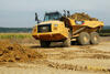 Kloubový dempr Caterpillar 730C2 přijíždí k deponii