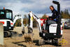Mikrorypadlo Bobcat E10, v pozadí Bobcat E26