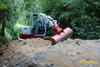 Takeuchi TB240 nabírá materiál pro zásyp