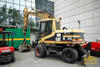 Kolové rypadlo Caterpillar M312 v zázemí veletrhu Intermat