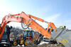 Pásové midirypadlo Hitachi Zaxis 85USB LCN, v pozadí rypadlonakladač Volvo BL71B
