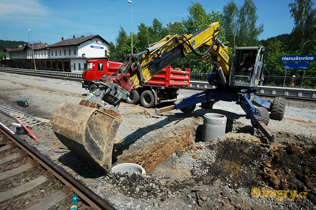 Hanušovice - Kráčivé rypadlo Kaiser S2 firmy Lesostavby Frýdek-Místek opatrně obsýpá betonovou šachtu
