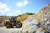 Kolový nakladač Caterpillar 966M XE obklopený kamenolomem v Mokré
